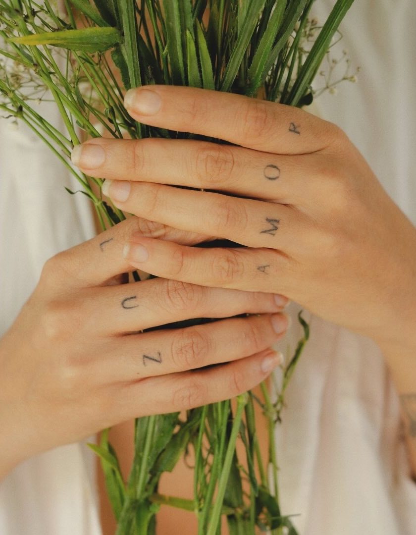Manos con los tatuajes luz y amor sosteniendo plantas